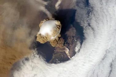Éruption du volcan Pic Sarytchev, dans les îles Kouriles au nord-est du Japon, le 12 juin 2009, vue depuis la Station spatiale internationale. La matière blanche sur le flanc du volcan est une coulée pyroclastique. Crédit : NASA